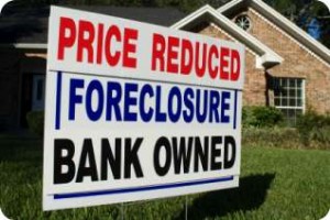 Price reduced bank owned foreclosure sign in front of home
